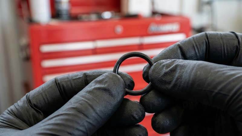 Руки в перчатках демонстрируют новые резиновые прокладки для устранения течи